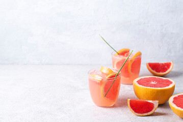 Refreshing low alcohol cocktail with grapefruit on a fresh stone background. Fruity light...