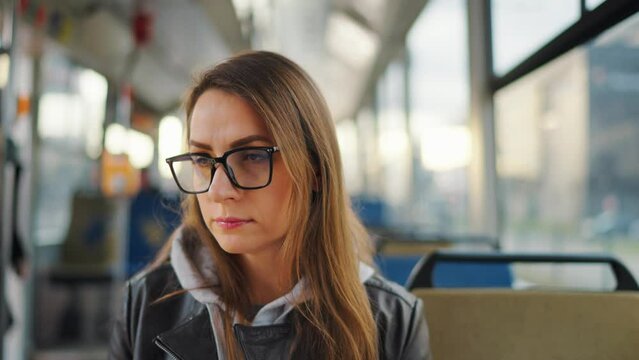 Public transport. Woman in glasses riding a tram in the city