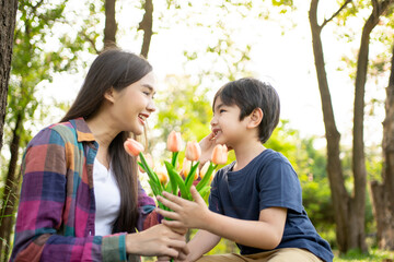 Happy Asian mother having fun with her son outdoors - Family and love concept. Mother’s day celebration.