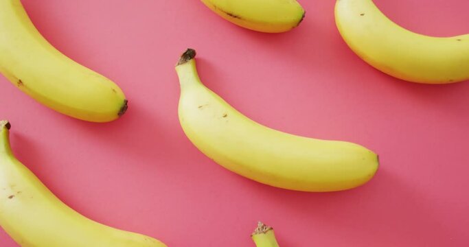 Video of fresh bananas on pink background