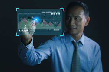 Businessman holding a pen and showing a growing virtual hologram of statistics, graph and chart with arrow up on the dark background. Stock market. Business growth.