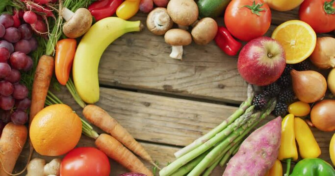 Video of fresh fruit and vegetables with heart shaped copy space over wooden background