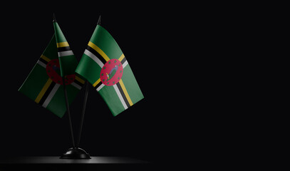 Small national flags of the Dominica on a black background