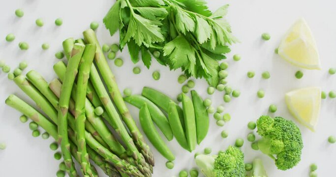 Video of close up of fresh green vegetables on white background