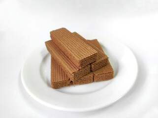Wafer cream chocolate flavoured on a white plate, isolated on a white background.