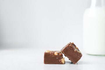 chocolate fudge with nuts on a marble tray, chocolate fudge cut into pieces, fudge candy on a marble tray
