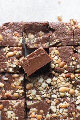 Top view of chocolate fudge with nuts on a marble board, chocolate fudge cut into pieces, fudge candy on a chopping board