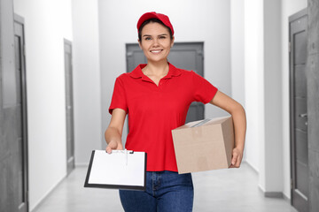 Smiling courier holding parcel and clipboard indoors