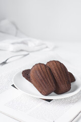 Chocolate madeleines on a ceramic plate, plain chocolate madeleine cake or cookies