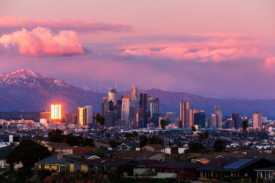 Downtown Los Angeles Skyline at Sunset with snowy Mountains during the Winter