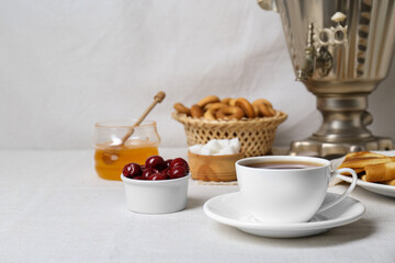 Aromatic tea, traditional Russian samovar and treats on table. Space for text