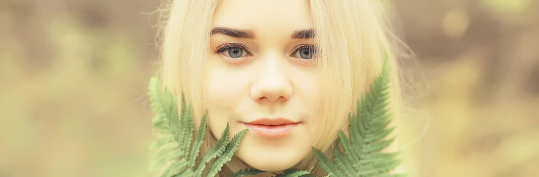 eco concept girl portrait fern, young adult model blonde, green leaf on face