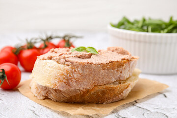 Delicious liverwurst sandwich with basil on white textured table, closeup