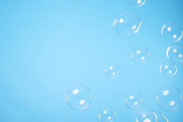 Many beautiful soap bubbles on light blue background. Space for text