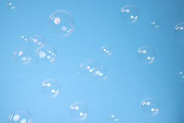 Many beautiful soap bubbles on light blue background. Space for text