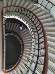 alone student with a backpack walking down the curved stairs at the university 