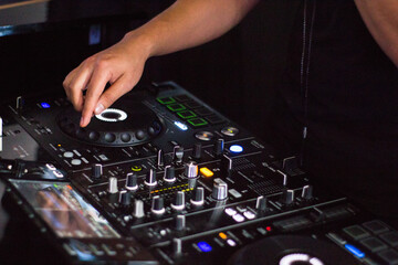 dj hand manipulating the mixing console 