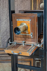 Old camera with lens on stand.