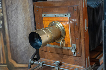Old camera with lens on stand.