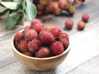 Rambutan fruits in a wooden bowl. Rambutan is tropical and asian fruits, sweet and Delicious,...