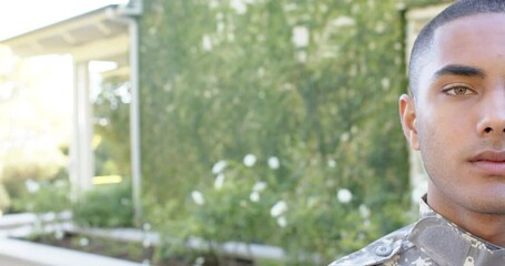 Portrait of happy biracial male soldier in garden
