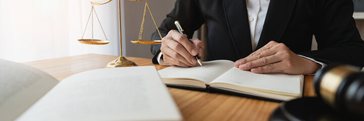Copy space, panorama, banner, Asian female lawyer or legal advisor. Justice sits at her desk and holds a pen to view detailed information on the level of jurisprudence to be studied.