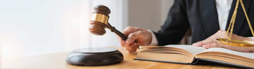Copy space, panorama. Lawyer, legal advisor, business woman reading a law book. and holding a hammer to knock deals, advice, justice in real estate business office.