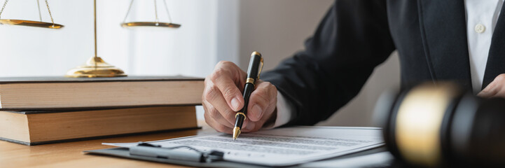 Asian female legal advisor or a lawyer using a pen to check business information and various...