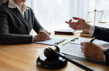 Young Asian lawyer or legal advisor explaining details of business contract agreement to investor holding hands before signing agreement to join business in office real estate project.