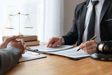 Young Asian lawyer or legal advisor explaining details of business contract agreement to investor holding hands before signing agreement to join business in office real estate project.