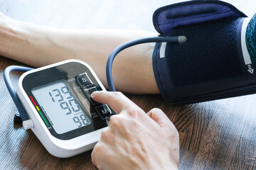 Man checks blood pressure monitor and heart rate monitor with digital pressure gauge. Health care...