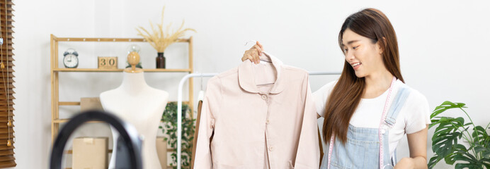 Beautiful woman with social media influences performing live or recording shows selling cheap fashion clothes in her studio, Recording vlog video live streaming, Online fashion clothing business.