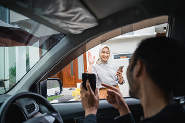 Fototapeta premium online transportation driver shows his cellphone while picking up a veiled female customer