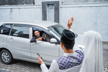 man in car shows cell phone when coming to Muslim couple's house waving and holding cell phone