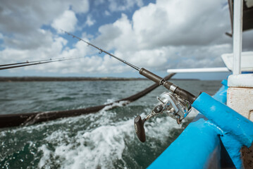 fishing rod mounted on a small fishing boat while sea fishing