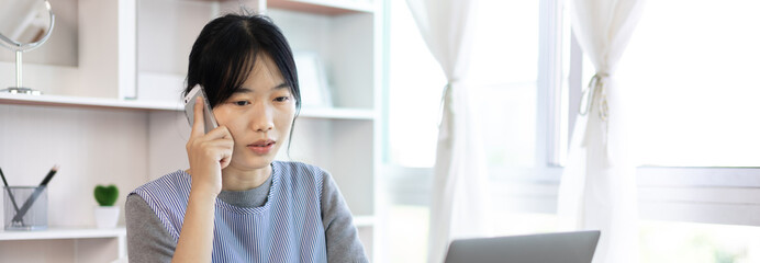 Finance workers are reviewing the company's financial data on a laptop and using smartphones to communicate or chat with the team during  social distances, Working alone in a private office.