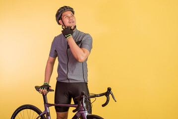thinking asian man touch his chin while standing beside his bicycle on isolated background