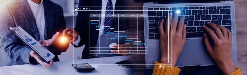 Project manager working with Gantt chart schedule to plan tasks and deliverables. Scheduling activities with a planning software, Corporate strategy for finance, operations, sales, marketing.