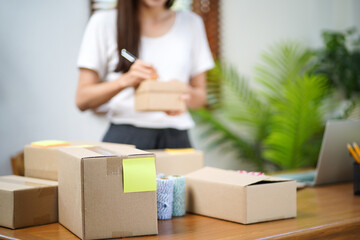 Asian woman preparing package delivery box Shipping for shopping online delivery mail service people and shipment concept