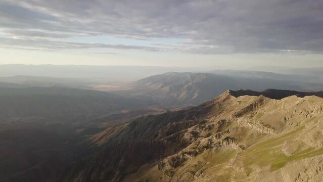 mt nebo salt lake city utah at sunrise sunset on a cloudy day with morning light spilling on the mountain - AERIAL TILT