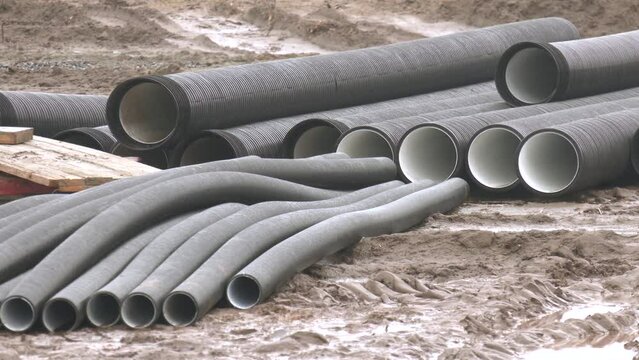 Sanitary piping. Plastic stacked PVC plastic industrial pipes. Plastic stacked PVC industrial pipes construction of housing project drainage canalization sewage. plastic water pipe lies on the ground 