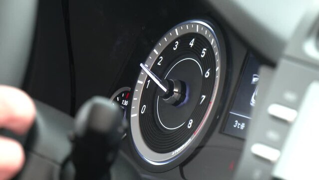 Instrument panel with tachometer. Close up image of illuminated car dashboard. Analog car tachometer. Revolutions per minute (RPM) indicator. 
