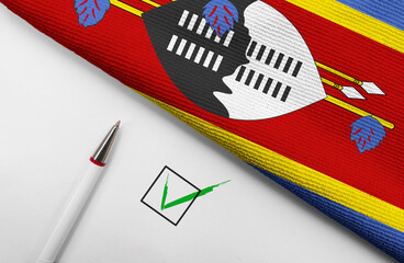 pencil, flag of Swaziland and check mark on paper sheet
