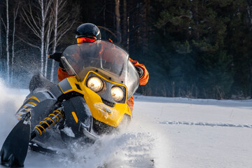 Athlete on a snowmobile moving in the winter forest in the mountains of the Southern Urals