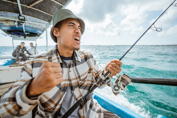 an angler's happy expression when the hook is eaten by a fish while fishing at sea