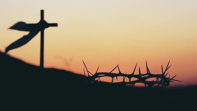 The cross and crown of thorns symbolizing the sacrifice and suffering of Jesus Christ and the red sunset, Passion Week and Lent Easter concept
