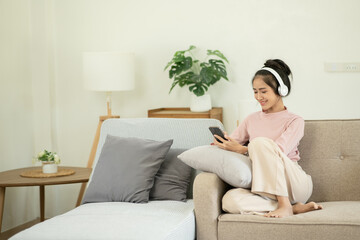 Asian woman watching movies, listening to music, video calling at home.