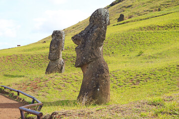 Group of abandoned massive Moai statues scattered on the slope of Rano Raraku volcano, historic Moai quarry on Easter Island, Chile, South America
