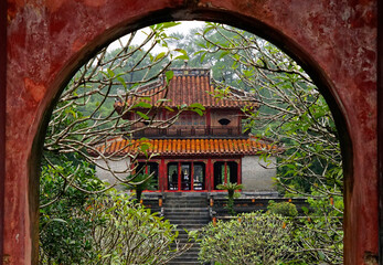 Pavilion inside Minh Mang Emperor Mausoleum viewed through arch gate in Hue, Vietnam on October 10, 2022
