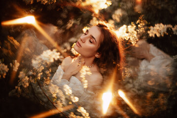Portrait of a romantic girl, like a forest nymph, in a blooming garden with elements of phantasmagoria. The concept of fantasy, fairy tales. - obrazy, fototapety, plakaty
